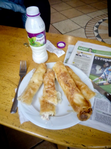 assortment of burek: cheese, potato, ham and cheese, cabbage with accompanying yogurt drink. The proper way to eat is to take a bite and follow up with a sip while the food is still in your mouth.